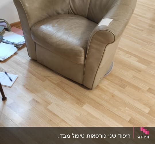 כורסה מרופדת מעור עם תיקון על הידית